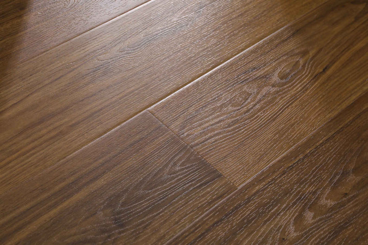 Close-up of medium brown wood flooring planks with visible grain patterns and a glossy finish.