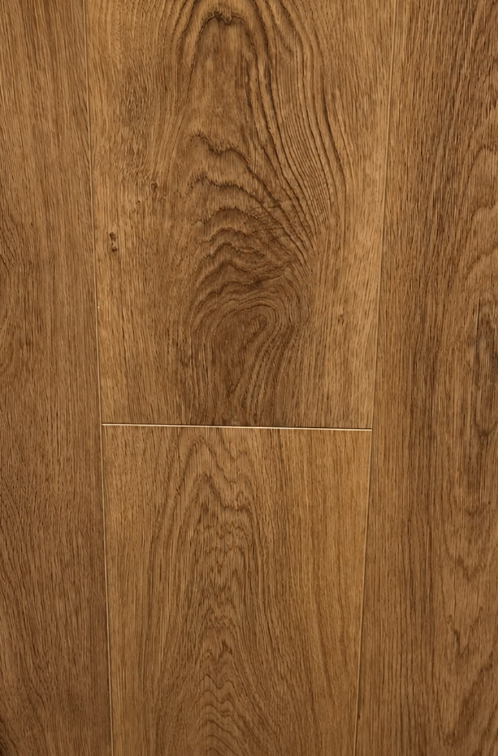 Close-up of warm medium-brown wood flooring planks with visible grain patterns and a horizontal seam near the center.