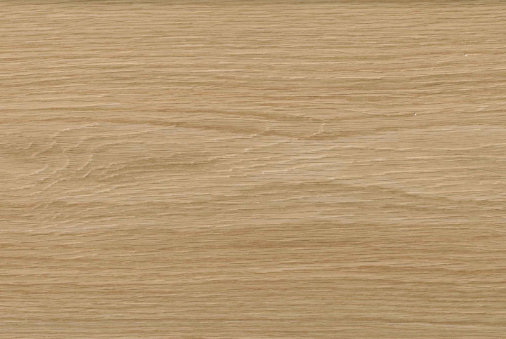 A close-up texture of a light oak wood grain surface, showing natural horizontal lines and subtle variations in tan and beige tones.