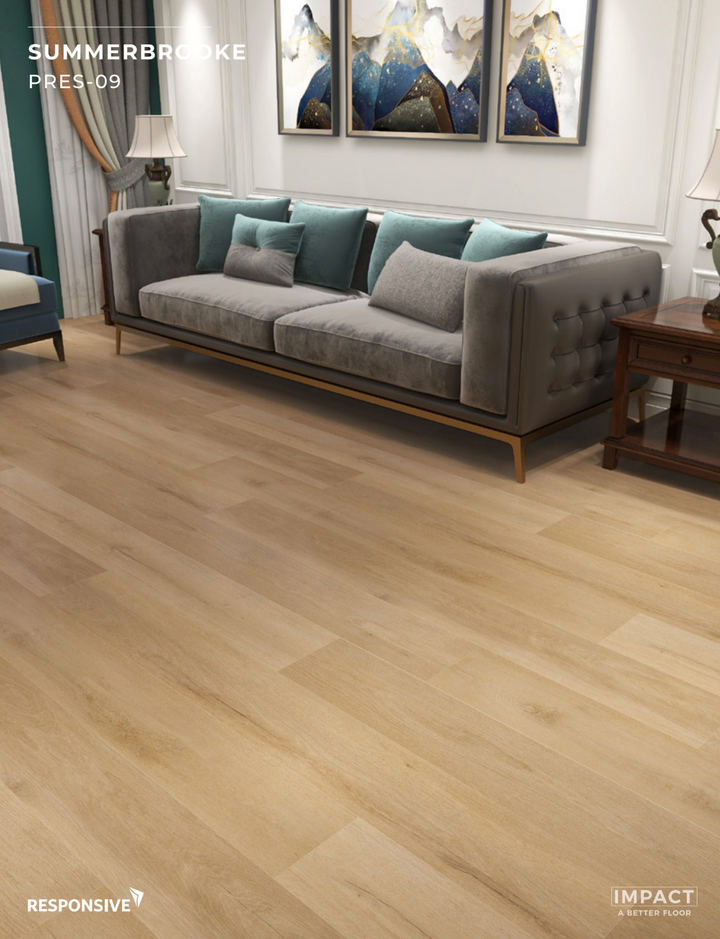 Gray sofa in a living room with wooden flooring and wall art.