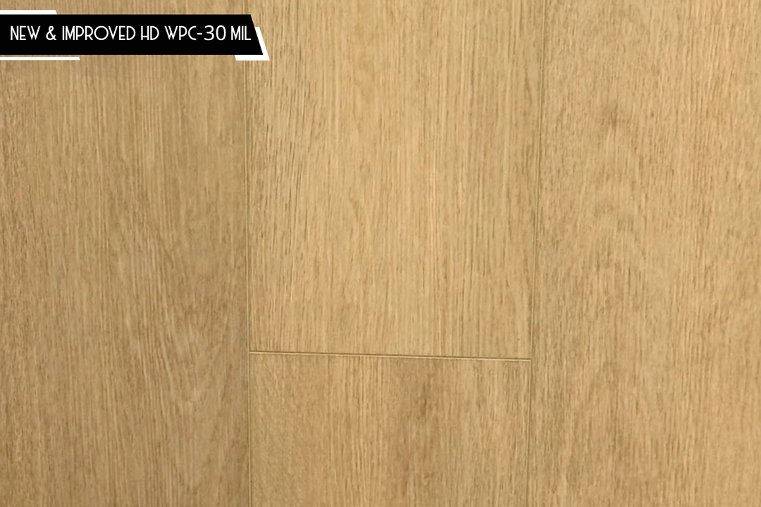 Light oak wood flooring planks with a warm beige-brown finish and visible grain texture, with a small black text banner in the top-left corner reading 'NEW & IMPROVED HD WPC-30 MIL'.