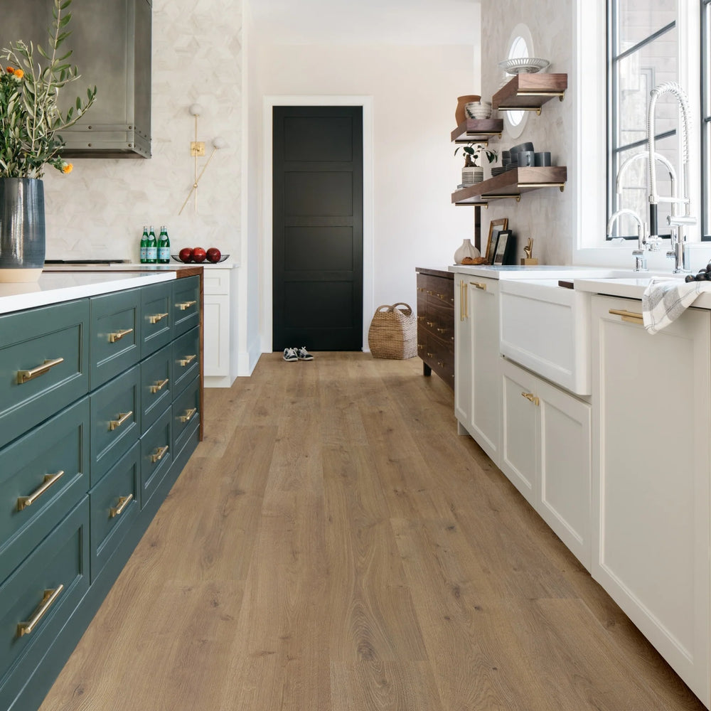 Modern kitchen with wooden flooring, white cabinets, and a black door.